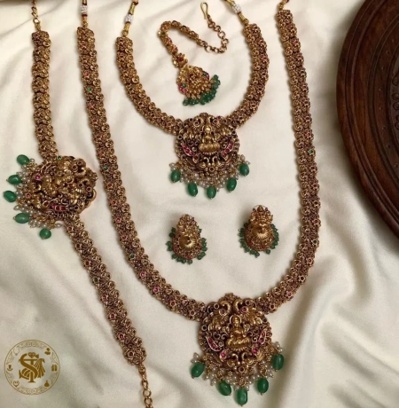 Antique Gold Plated Lakshmi Temple Jewelry Combo Set with Choker, Long Haram, Maang Tikka, Vanki, and Jhumkas